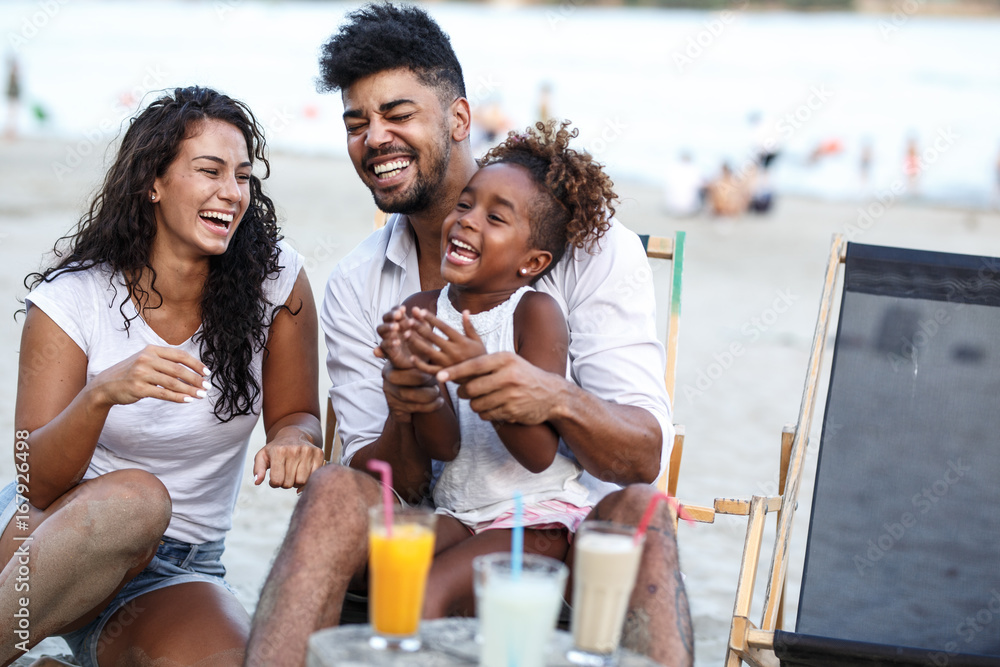family on the beach having a picnic laughing