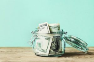 One hundred dollar bills in a jar
