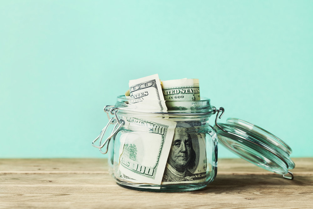 One hundred dollar bills in a jar